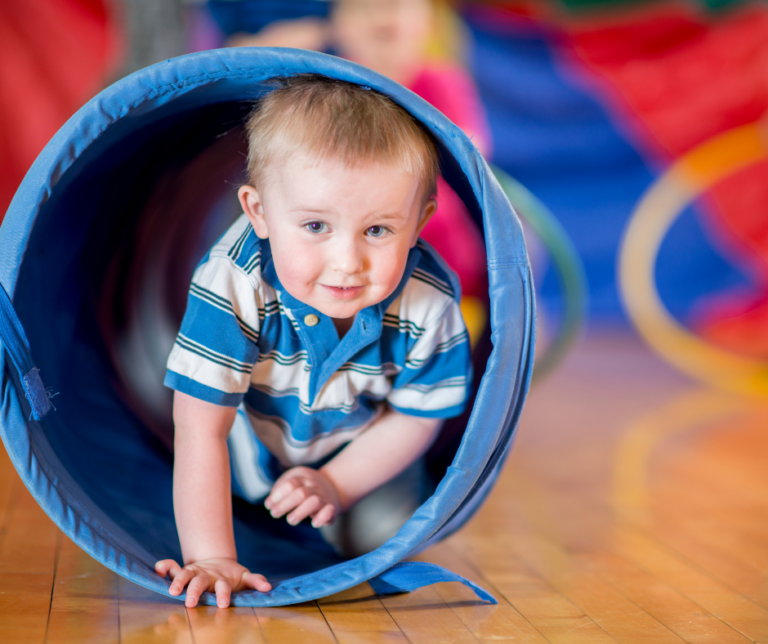 boy crawling through play tunnel