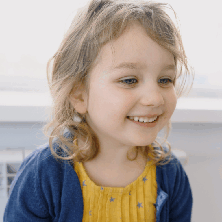 A child smiling and looking really proud
