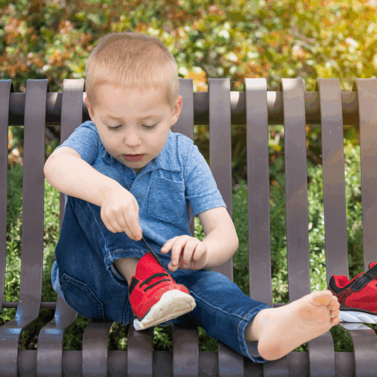 A child attempting to put their own shoes on