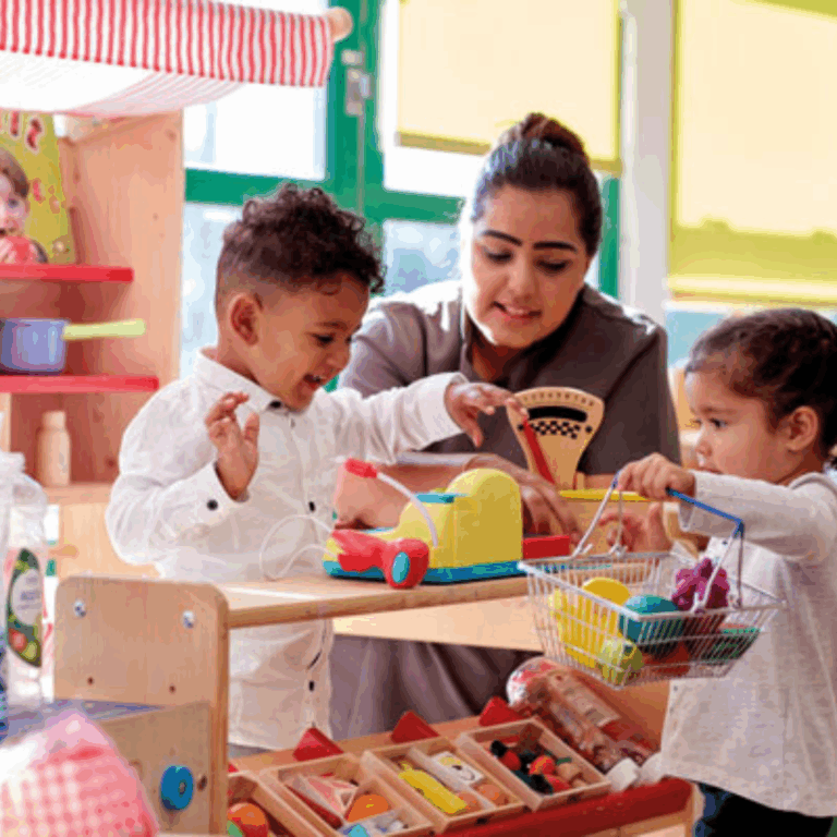 A confident practitioner playing in a role play shop with 2 preschoolers