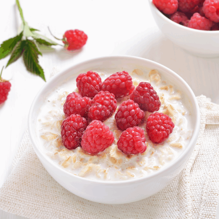 A bowl of porridge with raspberries