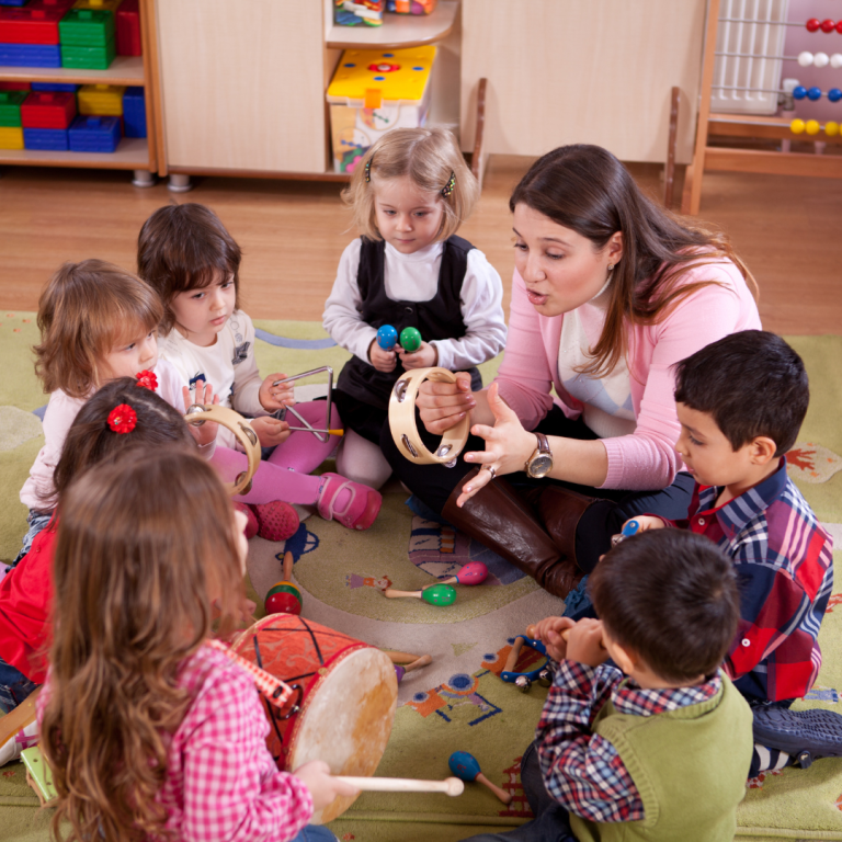 Group of preschoolers with a practitioner singing and playing untuned instruments