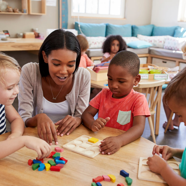 Teacher and preschooler at a table with shape and space resources
