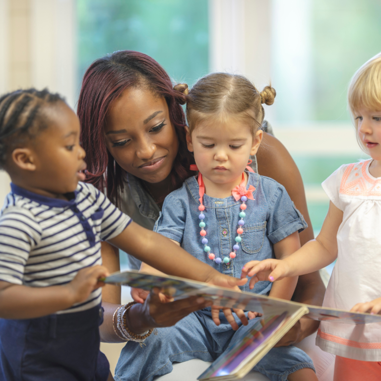A nursery practitioner sharing a story with some children