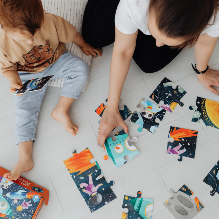 An image of sustained shared thinking with an adult and a preschooler solving a jigsaw puzzle together