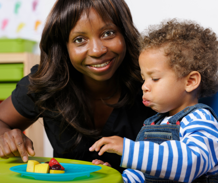An EYP supporting a child eating a snack
