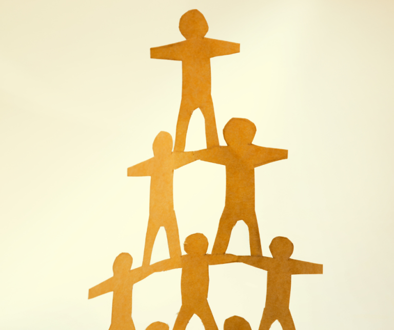 An image of a pyramid of paper people supporting each other