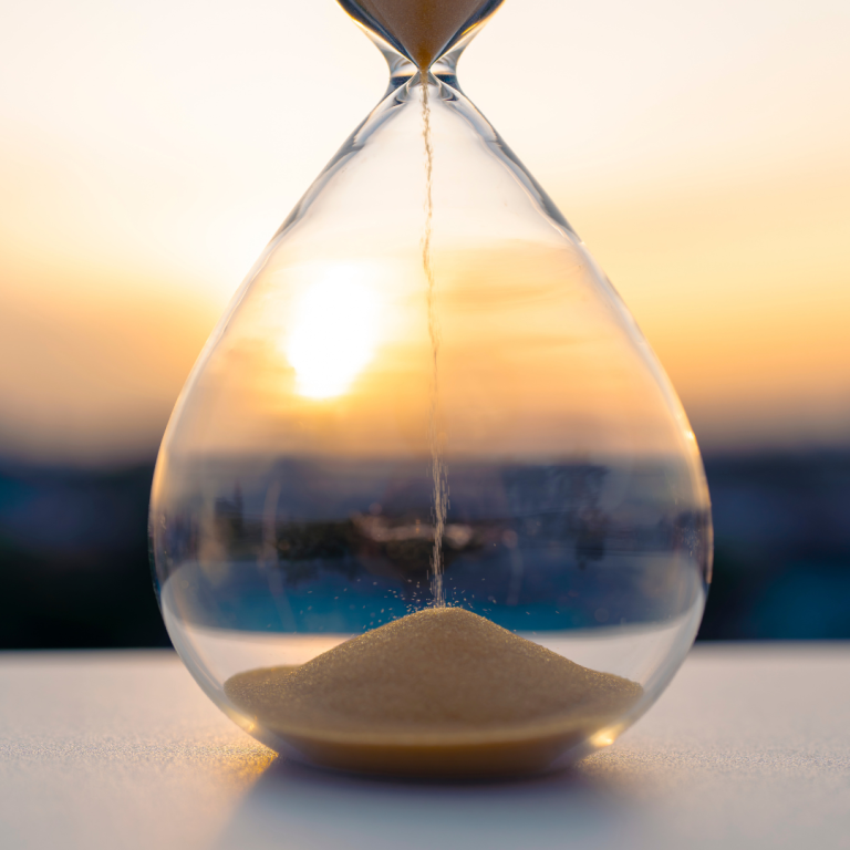 An hourglass against a sunset