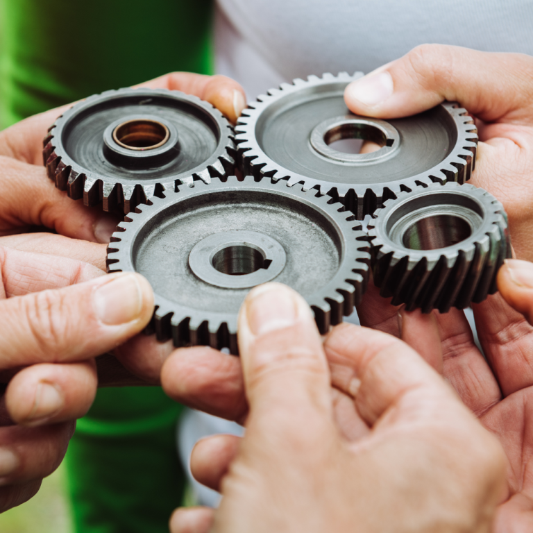 Hands holding cogs that fit together
