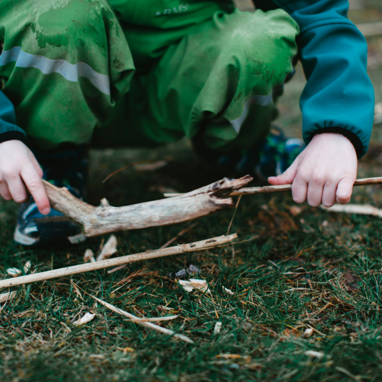 An image of a child in wet weather clothes exploring the outside area